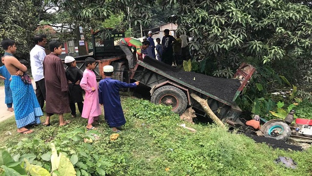 বাঘায় পুকুরে পড়লো পিচ বোঝাই ট্রলি